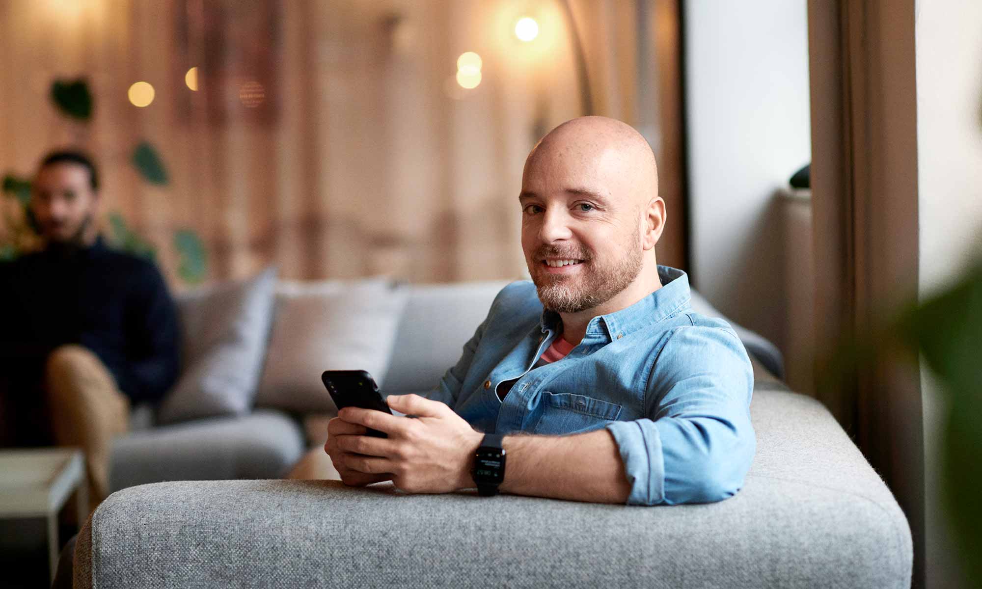 Man in blue shirt holding mobile phone